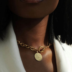 The Nigeria Crest and Palm Coin necklace by Omi Woods, available in solid gold or gold vermeil